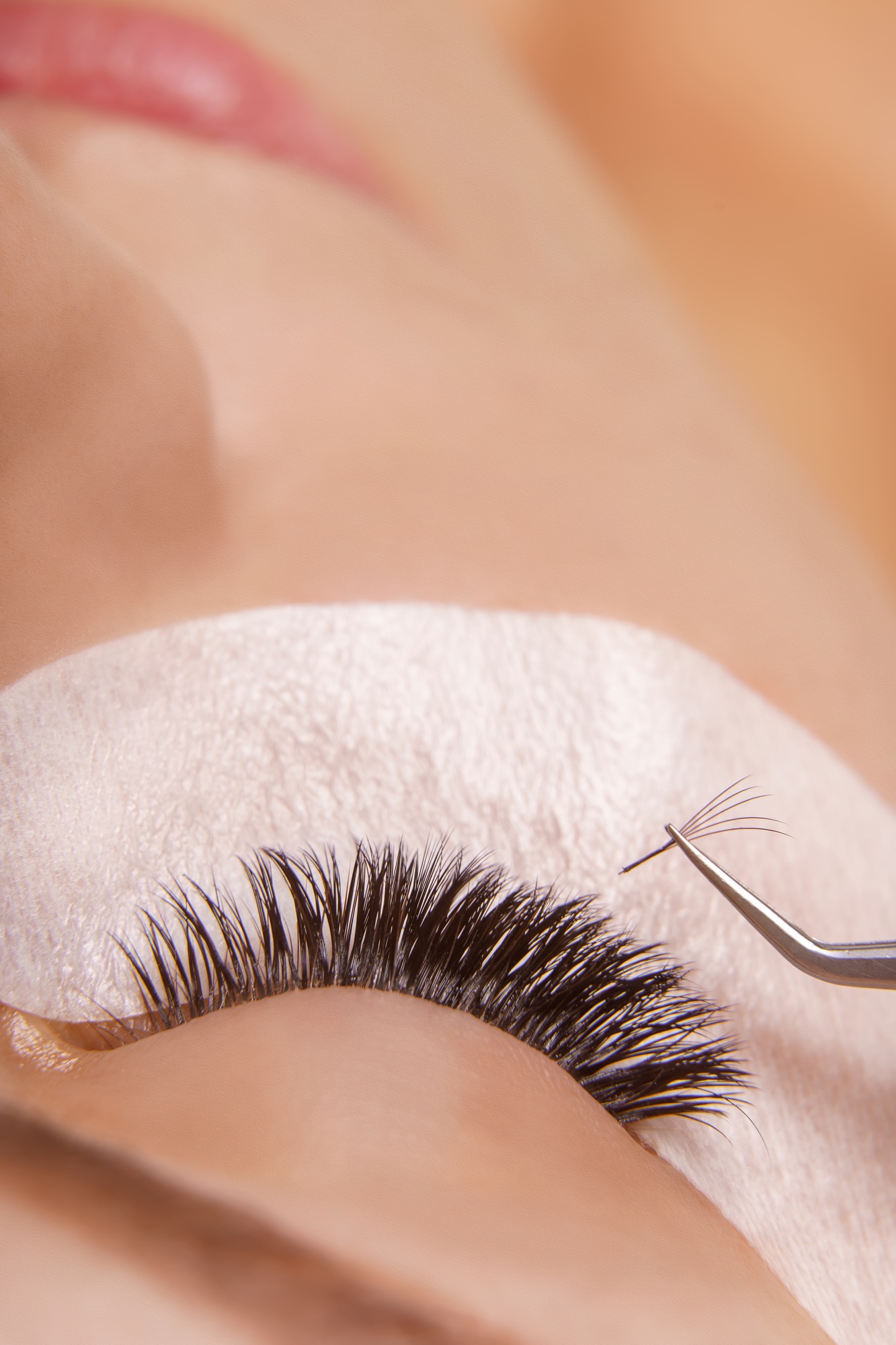 Eyelash Extension Procedure. Woman Eye with Long Eyelashes. Close up, selective focus