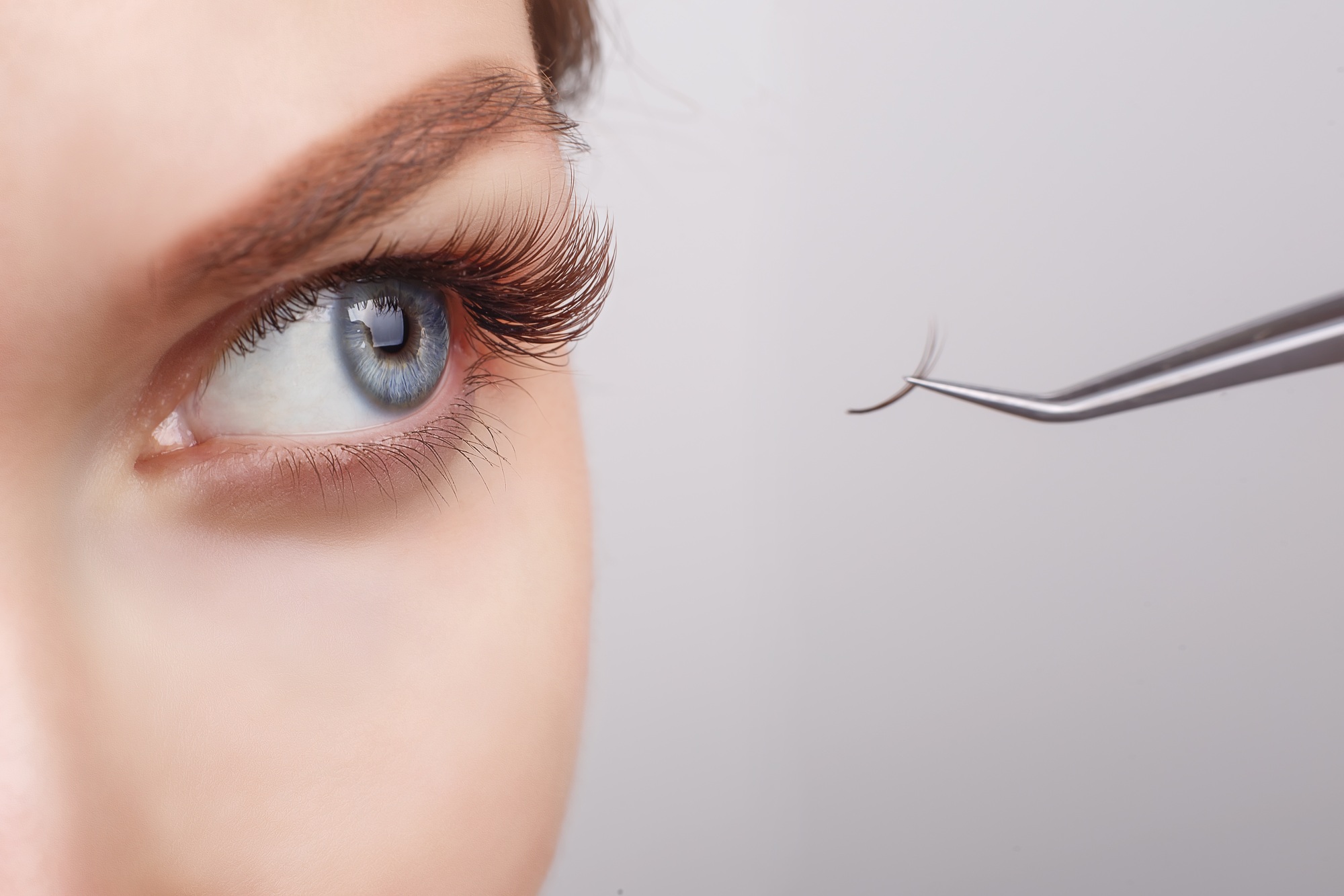 Eyelash Extension Procedure. Woman Eye with Long Eyelashes. Lashes, close up, selected focus