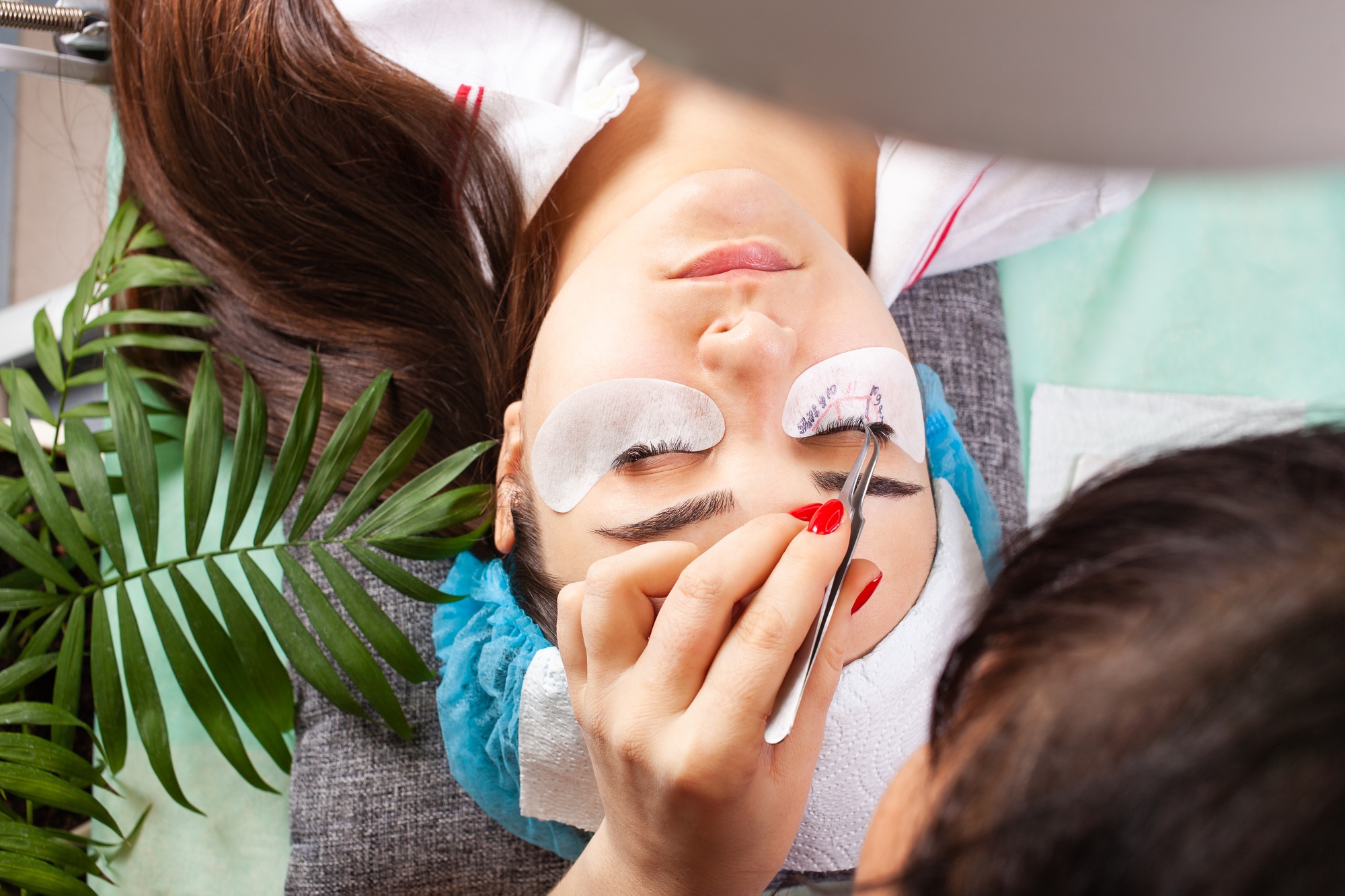 Eyelash extensions in a beauty salon. A young girl lies on a couch